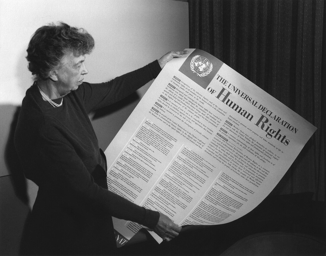 Eleanor Roosevelt mit einem Poster der Deklaration in englischer Sprache. FDR Presidential Library & Museum, CC BY 2.0 <https://creativecommons.org/licenses/by/2.0>, via Wikimedia Commons https://commons.wikimedia.org/wiki/File:Eleanor_Roosevelt_UDHR.jpg